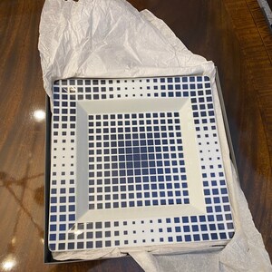 Puede incluir: Un plato cuadrado blanco para servir con un patr&oacute;n geom&eacute;trico azul. El plato est&aacute; en una caja con papel de seda.