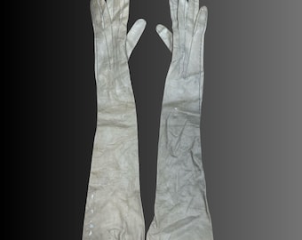 May include: A pair of long, white leather gloves. The gloves are made of a smooth, supple leather and have a classic, elegant design.
