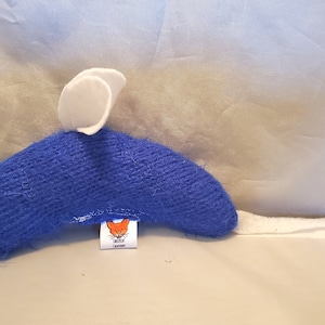 May include: Blue and white plush toy mouse with a white felt ear and a small orange label with a cat illustration. The label reads "The Cat's Meow".