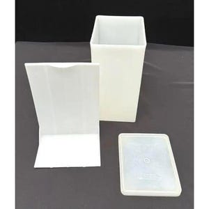 Peut inclure: Un ensemble de trois récipients en plastique blanc. L'un est une boîte rectangulaire haute, un autre est un support rectangulaire et le troisième est un couvercle rectangulaire. Les récipients sont vides et semblent propres.