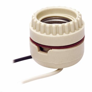 May include: A cream-colored light bulb socket with a ridged top and a red band. Black and white wires extend from the base. The socket is designed to hold a light bulb and connect to a power source.