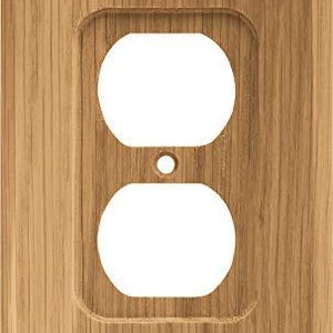 Pode incluir: Uma placa de parede retangular de madeira clara com uma abertura para uma tomada elétrica dupla. A madeira apresenta linhas de grão verticais. As aberturas da tomada são brancas.
