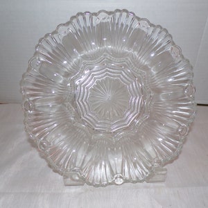 Peut inclure: Un plat de service en verre transparent avec un bord festonné et un motif en étoile au centre.