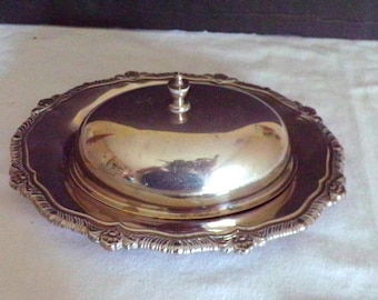 May include: A silver butter dish with a domed lid and a decorative, scalloped edge.