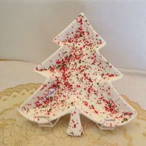 Op de afbeelding: Witte keramische kerstboomschotel met rood en groen gespikkeld glazuur. De schotel heeft drie secties en is perfect om snacks of hapjes te serveren.