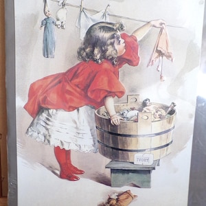 May include: Vintage print of a girl in a red dress hanging laundry. The image shows a girl reaching for a cloth on a clothesline, with dolls in a wooden tub. The print has a nostalgic, antique aesthetic.