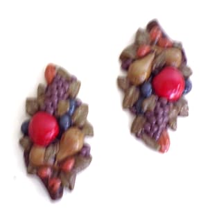 Könnte beinhalten: Ein Paar Vintage-Ohrringe mit einem Cluster aus Früchten und Blättern in Braun-, Rot- und Lilatönen. Die Ohrringe sind aus Kunststoff und haben eine strukturierte Oberfläche.