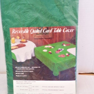 May include: Reversible quilted card table cover with green and white fabric. Play cards on top, reverse to tablecloth for serving. Edges are neatly sewn. Easy care, wipe in a jiffy. Polyester fiber insulation, vinyl top and bottom. Fits all square bridge tables, 45 x 45 inches. Fits all round bridge tables, 54 inch round. No. 32211, No. 32214. Made in U.S.A.