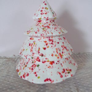 May include: A white, tiered Christmas tree decoration with a speckled pattern of red, orange, and green. The tree has a textured surface and a conical top, perfect for holiday decor.