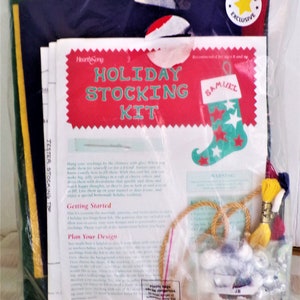May include: A holiday stocking kit featuring a red, white and green stocking design. The kit includes felt, embroidery floss, beads and instructions. The kit is packaged in a clear plastic bag with a HearthSong Exclusive label.