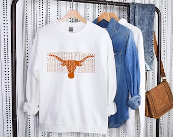 May include: White sweatshirt with an orange Longhorn steer head graphic and the text "Hook 'em" repeated multiple times.