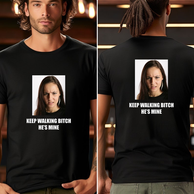 May include: Black t-shirt with a white graphic of a woman's face and the text "KEEP WALKING BITCH HE'S MINE".