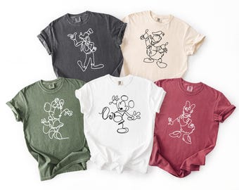 May include: Five t-shirts in various colors, each featuring a different cartoon character outline in white. The shirts are in shades of gray, green, cream, white, and burgundy. The white shirt has the text "Love"