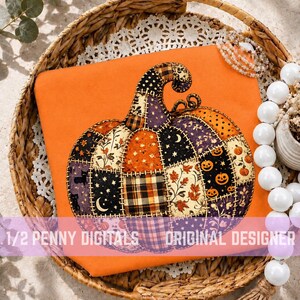 May include: A bright orange t-shirt featuring a large, central graphic of a patchwork pumpkin. The pumpkin is composed of various fabric patterns including plaid, floral, moon and star motifs, and jack-o'-lantern faces. Text reads 1/2 PENNY DIGITALS ORIGINAL DESIGNER.