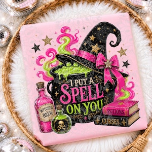 May include: A pink square fabric print featuring a black witch hat with a pink bow, a bubbling green cauldron, and two glass bottles labeled Witches Brew. The text I PUT A SPELL ON YOU is centered above two stacked books labeled Potions and Curses.