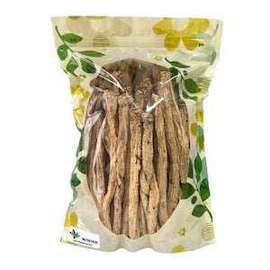 May include: A clear plastic bag with a floral pattern contains a bundle of dried, light brown ginseng roots. The bag has a label that says "NUTRITION".