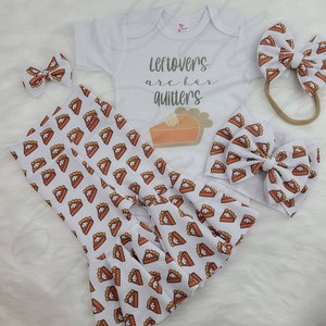 May include: A white baby onesie with the text "Leftovers are for quitters" and a pie graphic. The onesie is paired with a white headband and a pair of white trousers with a pie pattern.