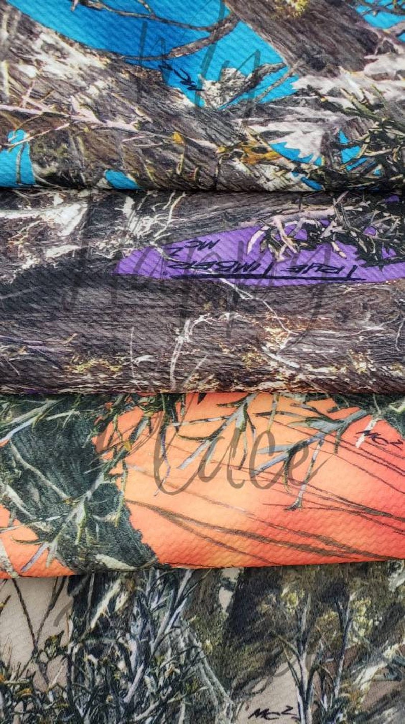 May include: Close-up of several fabric swatches with camouflage patterns. The colors include blue, purple, orange, and various shades of brown and green. Some swatches have text. The fabric has a textured appearance.