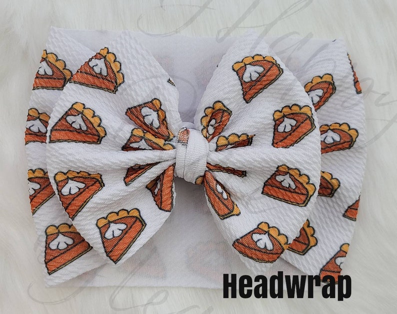 May include: White headband with a large bow made of white fabric with a pumpkin pie print. The text "Headwrap" is printed on the bottom of the image.