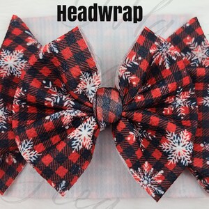 May include: A red and black plaid headwrap with white snowflake accents. The headwrap has a large bow in the center and the word "Headwrap" is printed in black at the top.