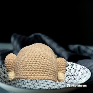 May include: A crocheted beige hat shaped like a turkey with two small brown and beige turkey legs.