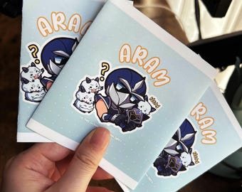 May include: Three light blue greeting cards featuring a cartoon illustration of a masked character in dark blue armor with white accents. The character is surrounded by small white creatures and the text ARAM and NOM with a question mark.