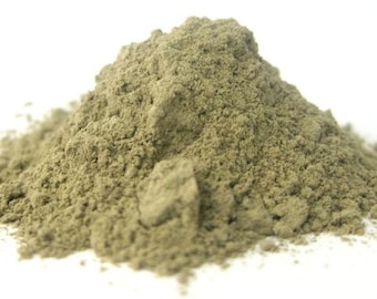 May include: A pile of fine, light green powder against a white background. The powder has a slightly coarse texture and is piled into a small mound. The color is a muted, earthy green.