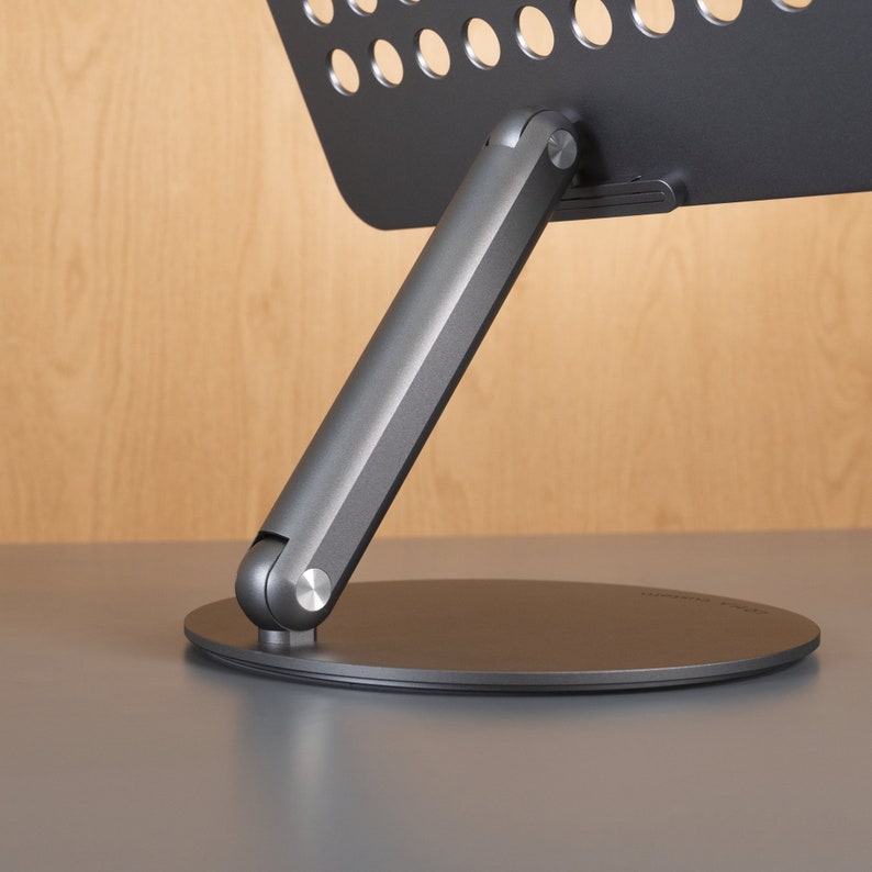 A laptop stands on a wood-colored background with details of the rotating shaft displayed.
