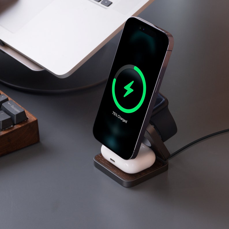 A 3 in 1 charger that charges iPhones, AirPods, and Apple Watches sits next to the computer.