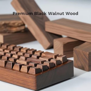 May include: A wooden keyboard with keycaps and a frame made of dark brown black walnut wood. The image also shows several blocks of the same wood, and the text "Premium Black Walnut Wood".