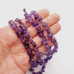 May include: A strand of amethyst chip beads, featuring a mix of light and dark purple hues. The beads are irregular in shape and size, creating a natural and organic look.