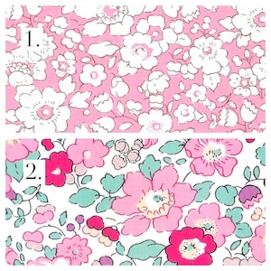 May include: Two fabric swatches with floral patterns. Swatch 1 features white flowers on a light pink background. Swatch 2 displays a dense arrangement of pink, magenta, and light green flowers with small purple accents on a white background.