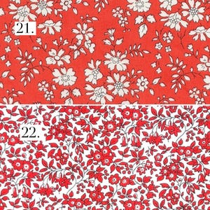 May include: Two fabric patterns labeled 21 and 22. Pattern 21 features white floral illustrations on a vibrant red background. Pattern 22 displays dense red floral and leaf motifs on a clean white background, creating a contrasting botanical design.