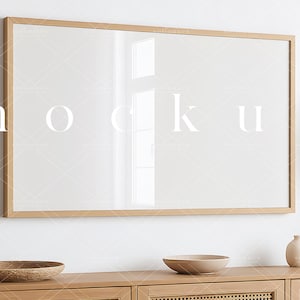 May include: A light wood framed mirror hangs on a white wall above a light wood dresser with two drawers. The dresser has a woven cane front. Two light brown bowls are on the dresser.