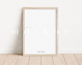 May include: A light wood frame mockup with a white background. The frame is sitting on a light wood floor. The text "JPG-PSD" is printed in the bottom right corner of the frame.