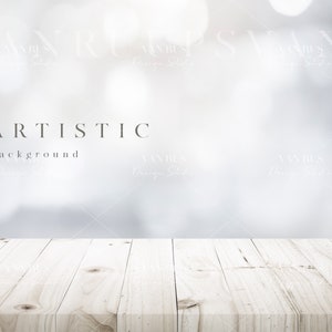 May include: A white wooden tabletop with a blurred white and gray background. The text "ARTISTIC background" is visible in the center of the image.