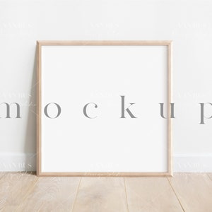 May include: A simple wooden frame mockup with a white background. The frame is sitting on a light wood floor against a white wall. The word "mockup" is written in grey text on the wall.
