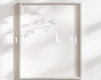 May include: A white rectangular frame mockup with the word "mockup" in the center. The frame is set against a white wall with shadows of leaves. The word "frame" is above the word "mockup".