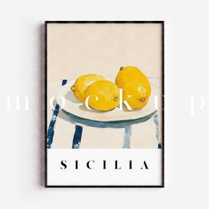 May include: A framed print with a painting of three lemons on a white plate with blue and white stripes in the background. The text "SICILIA" is printed below the plate.