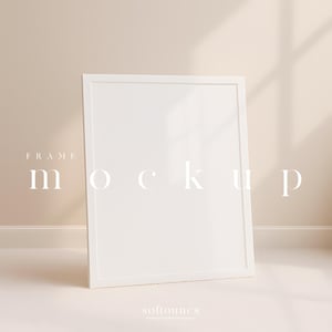 May include: A white rectangular frame mockup leaning against a beige wall. The word "FRAME" is above the word "mockup" in a minimalist font. The bottom of the frame is resting on a light beige floor. The shadow of a window is cast on the wall.