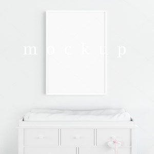 May include: White changing table with three drawers and a white frame around a blank canvas print.