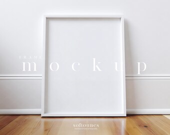 May include: A white rectangular frame mockup leaning against a white wall. The frame is empty, with the word "mockup" in white text across the frame. The frame is on a wooden floor. The words "softounes" and "minimalist & styled photography" are at the bottom.