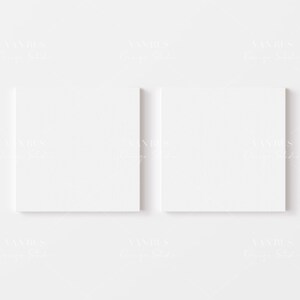 Puede incluir: Dos lienzos blancos en blanco se muestran en una pared blanca. Los lienzos son cuadrados y tienen una superficie texturizada.