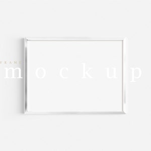 Peut inclure: Maquette de cadre photo blanc avec le texte "FRAME MOCKUP" imprimé en gris clair.