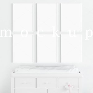 May include: A white chest of drawers with four drawers and a changing mat on top. There are six white picture frames hanging on the wall above the dresser.