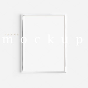 Puede incluir: Una maqueta de marco de imagen blanco con el texto "FRAME MOCKUP" en una fuente marrón claro.