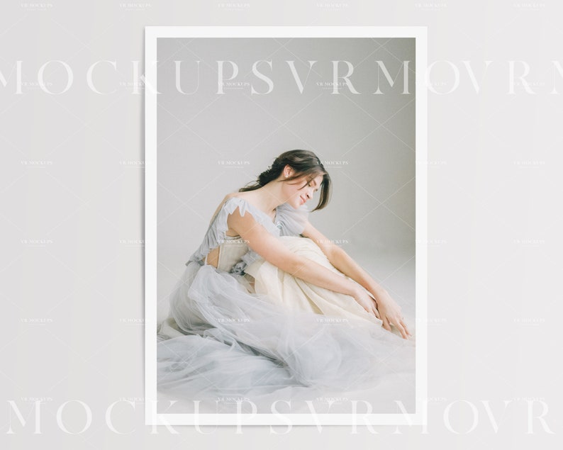 May include: A woman in a light blue tulle dress sits on a white floor with her head down. The dress has a white bodice with a ruffled neckline.