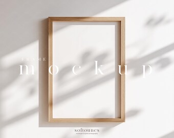 Pode incluir: Maquete de moldura retangular de madeira com interior branco, sobre uma parede branca. A moldura é castanho claro, e o texto "FRAME mockup" é exibido em branco. A imagem tem sombras suaves.