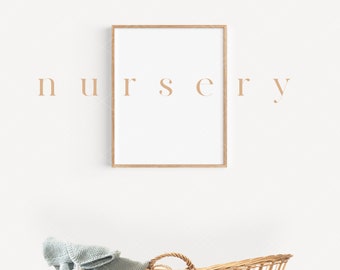 Puede incluir: Una pared blanca con un marco de madera alrededor de un póster blanco en blanco con la palabra "nursery" escrita en una fuente marrón claro. Un moisés de mimbre con una manta de punto azul claro está en la esquina inferior derecha de la imagen.
