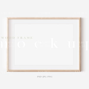 May include: A simple, light wood frame with a white mat and a white background. The frame is perfect for displaying photos, artwork, or other decorative items.  The text "WOOD FRAME" is printed in a light brown color at the bottom of the image.